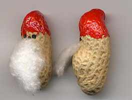 Erdnuss Weihnachtswichtel: mit rotem Filzstift wird der Hut aufgemalt, mit schwarzem Filzstift das Gesicht, mit Watte wird ein Bart angeklebt.