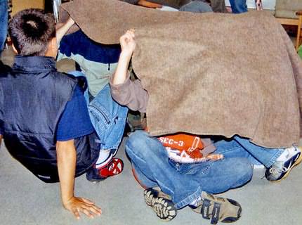 Deckenspiel: Die Gruppe versteckt sich unter einer Decke.