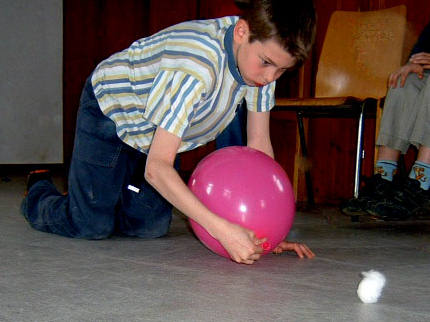 Ein Wattebausch wird mit Hilfe eines Luftballons geblasen.