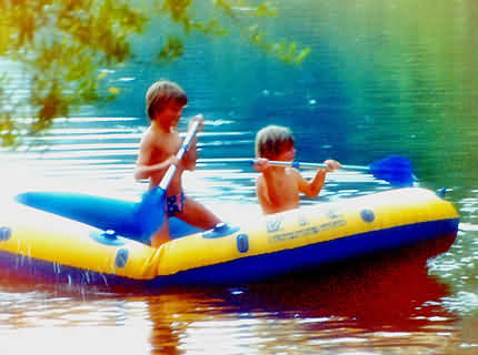 Kinder paddeln mit einem Schlauchboot