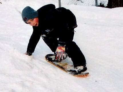 Mit dem Skateboard ohne Rollen die Rodelbahn hinunter